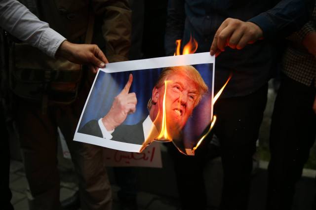Iranians burn a photo of Donald Trump. Credit:  Maryam Rahmanian/UPI