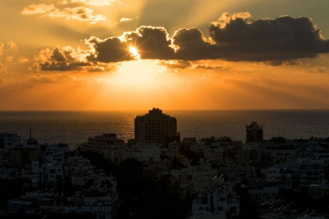 The sun sets over Tel Aviv's skyline, Israel, on June 21, 2017. / AFP PHOTO / JACK GUEZ        (Photo credit should read JACK GUEZ/AFP/Getty Images)