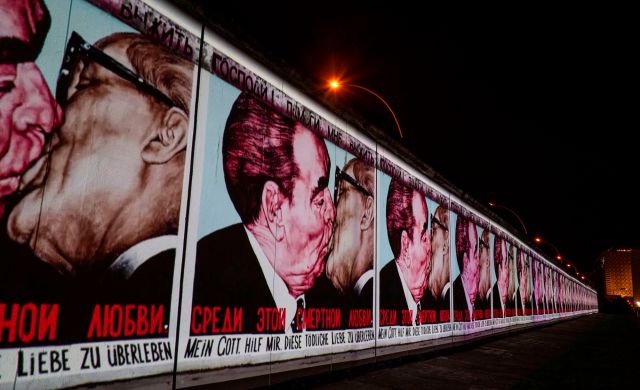 Mural depicting the kiss between then Soviet leader Leonid Brezhnev (L) and East German leader Erich Honecker is projected on a stretch of the Berlin wall. Credit: John Macdougall / AFP / Getty