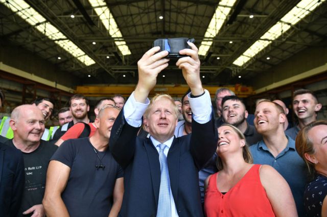 Boris Johnson takes a selfie with workers at the Wight Shipyard Company. Credit:  Dominic Lipinski - WPA Pool / Getty
