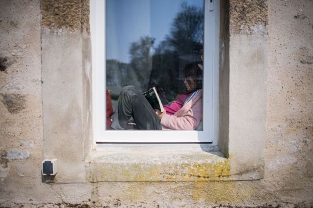 If you can't escape home, you can at least escape into a book. Credit: LOIC VENANCE/AFP via Getty Images