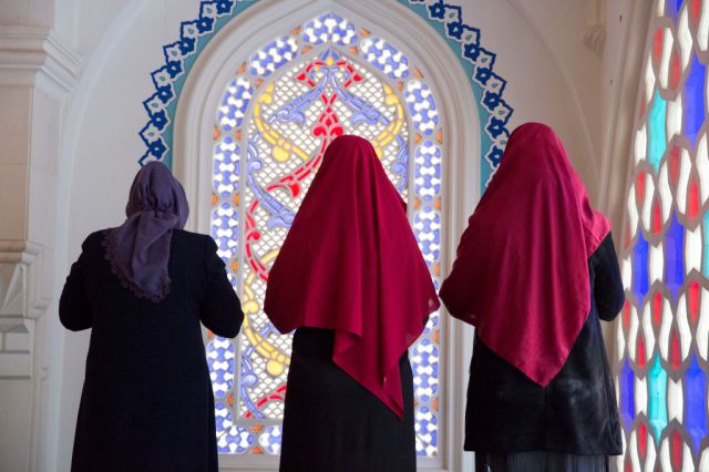 Three Muslim women during midday prayers.  Credit: Omer Messinger/Getty