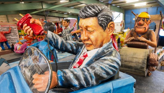 A float in Germany depicts Xi Jinping pulling the plug on an electric car and leaving German carmakers behind. Credit: Getty