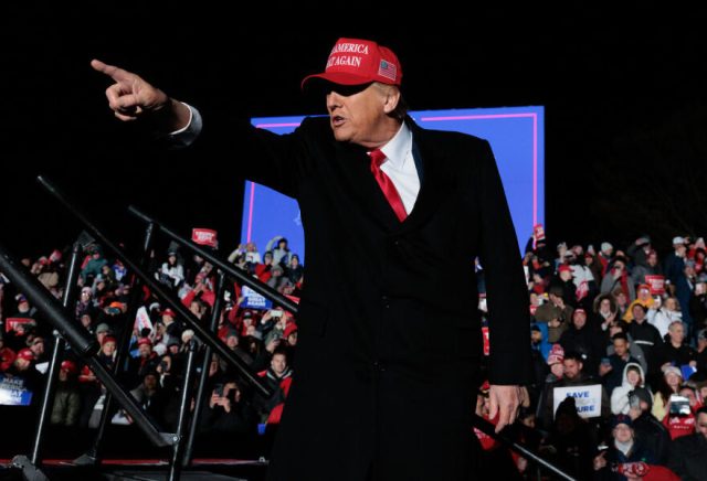 'Ambling on stage, more bronzed than usual, he raises a fist of defiance to one section of the crowd' (Hannah Beier/Bloomberg via Getty Images)