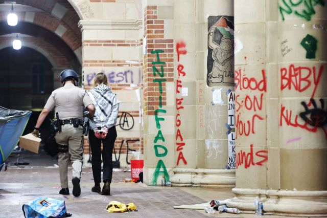 A California Highway Patrol officer detains a protestor at UCLA this week. Credit: Getty