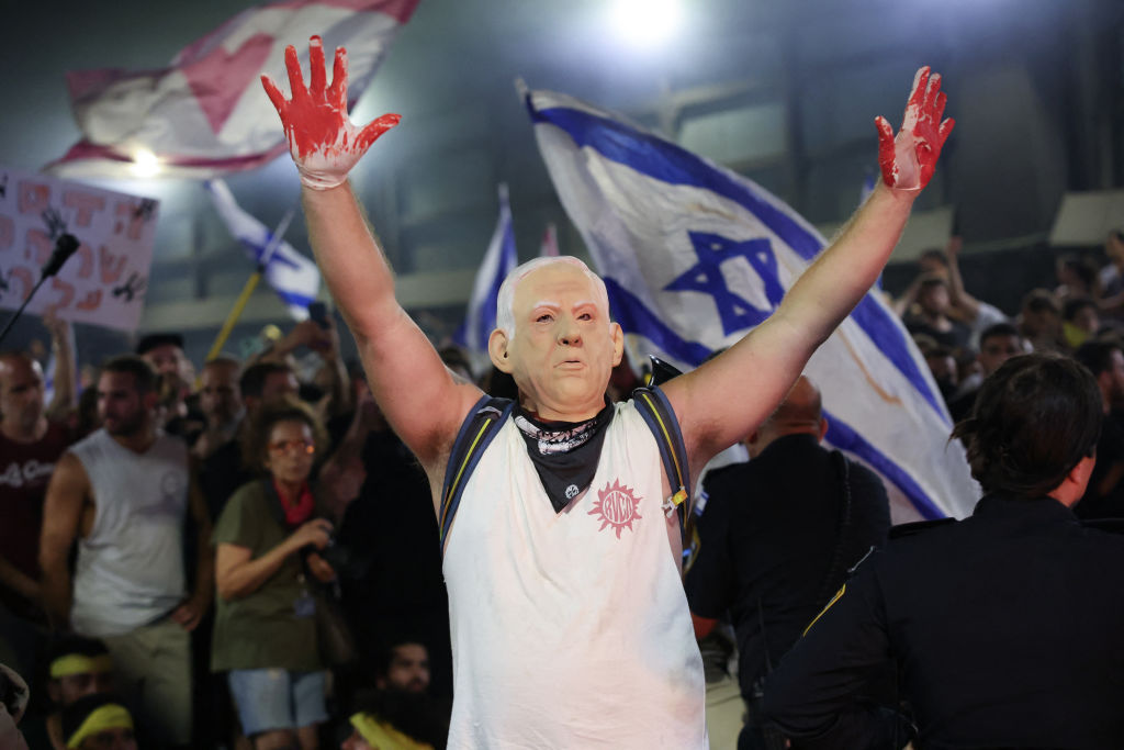 A protester wears a mask depicting Benjamin Netanyahu in Tel Aviv yesterday. Credit: Getty