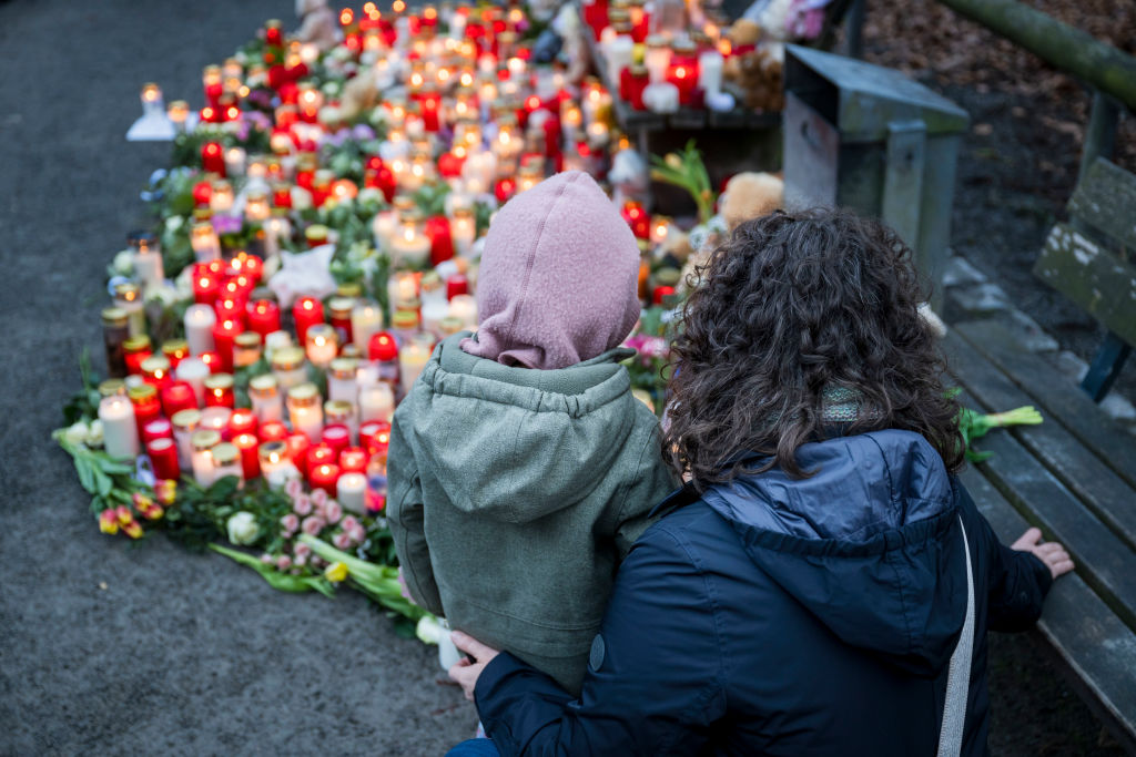 Mourners visit the site of Wednesday's stabbing attack in Aschaffenburg, which killed two people including a toddler. Credit: Getty