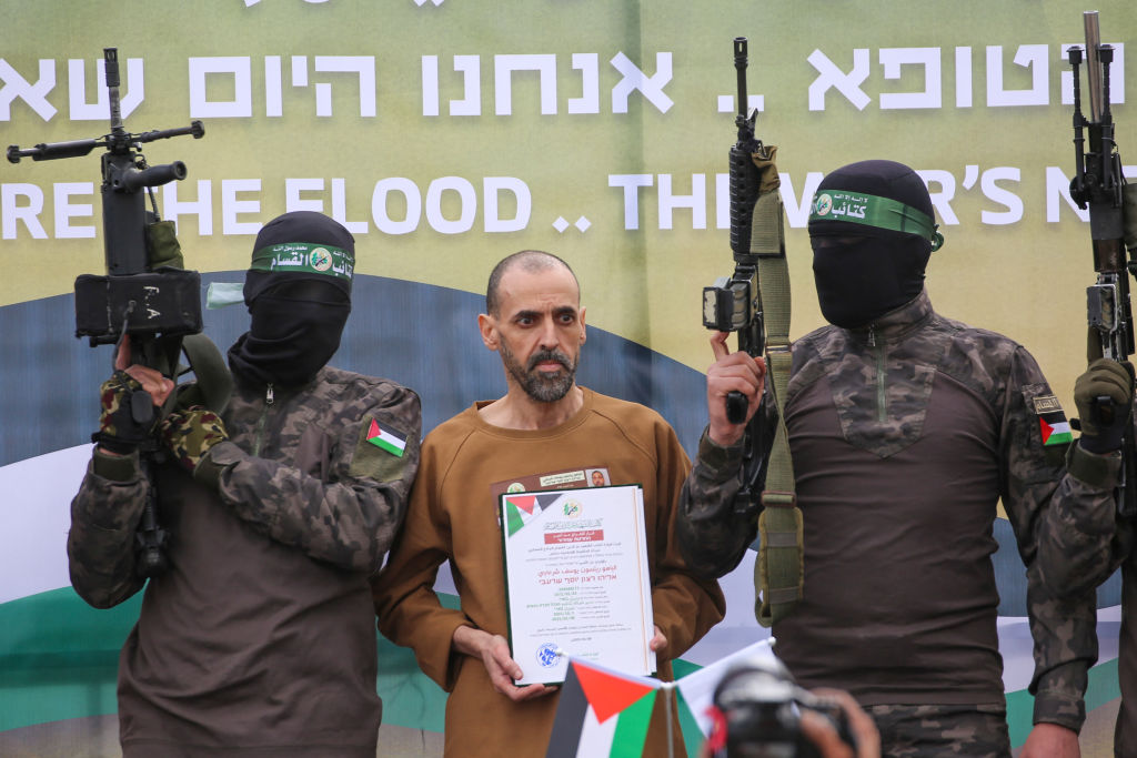 Hamas members escort Israeli hostage Eli Sharabi on a stage before handing him over to a Red Cross team in Gaza at the weekend. Credit: Getty