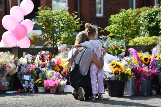 A mother and her child gather at a memorial to the Southport victims in 2024. Credit: Getty