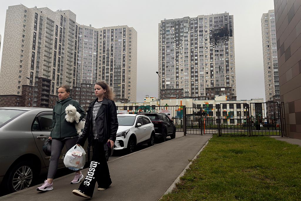 Moscow residents walk past an apartment building damaged by Ukrainian strikes this weekend. Credit: Getty